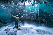 Adventurer photographs cave below a glacier, Juneau, Alaska - Au