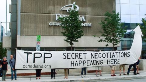 Members of a Canadian citizens' group hold a banner demanding information disclosure in Ottawa on July 7, 2014, in front of the venue of Trans-Pacific Partnership free trade talks being held behind closed doors. (Kyodo)