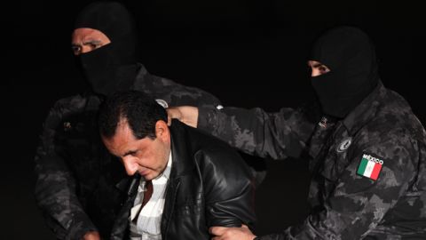 Flavio Gomez, identified by police as the brother of Servando "La Tuta" Gomez, the head of the Knights Templar drug cartel, is escorted to a federal police truck at the airport in Mexico City, Friday, Feb. 27, 2015. Servando Gomez, a former school teacher who became one of Mexico's most-wanted drug lords, was captured early Friday by federal police in Morelia, the capital of the western state of Michoacan.(AP Photo/Marco Ugarte)