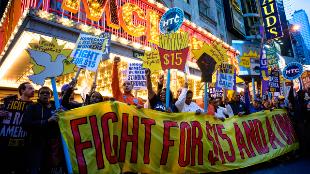 Protestors pause near a McDonald's restaurant in Times Square during a rally and march in New York, Wednesday, April 15, 2015, as participants, fast food workers and union members, call for a $15 minimum wage. (AP Photo/Craig Ruttle)