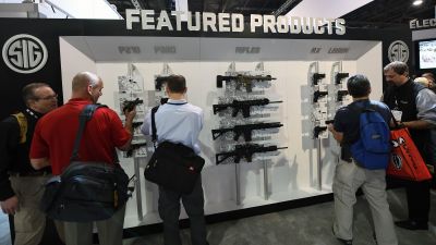 LAS VEGAS, NV - JANUARY 19: Convention attendees look at firearms displayed at the Sig Sauer booth at the 2016 National Shooting Sports Foundation's Shooting, Hunting, Outdoor Trade (SHOT) Show at the Sands Expo and Convention Center on January 19, 2016 in Las Vegas, Nevada. The SHOT Show, the world's largest annual trade show for shooting, hunting and law enforcement professionals, runs through January 23 and is expected to feature 1,600 exhibitors showing off their latest products and services to more than 62,000 attendees. (Photo by Ethan Miller/Getty Images)