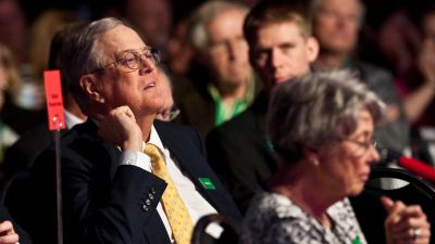 David Koch listens to Republican presidential hopeful Mitt Romney addressing the "Defending The American Dream Summit" organized by Americans for Prosperity in Washington, DC on November 4, 2011. (NICHOLAS KAMM/AFP/Getty Images)