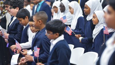 Children hold US flags as US President Barack Obama speaks in an overflow room during a visit to the Islamic Society of Baltimore, in Windsor Mill, Maryland on February 3, 2016. Obama offered an impassioned rebuttal of "inexcusable" Republican election rhetoric against Muslims Wednesday, on his first trip to an American mosque since becoming president seven years ago. / AFP / MANDEL NGAN (Photo credit should read MANDEL NGAN/AFP/Getty Images)