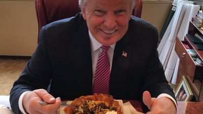Picture of Donald Trump eating a Trump taco bowl and smiling.