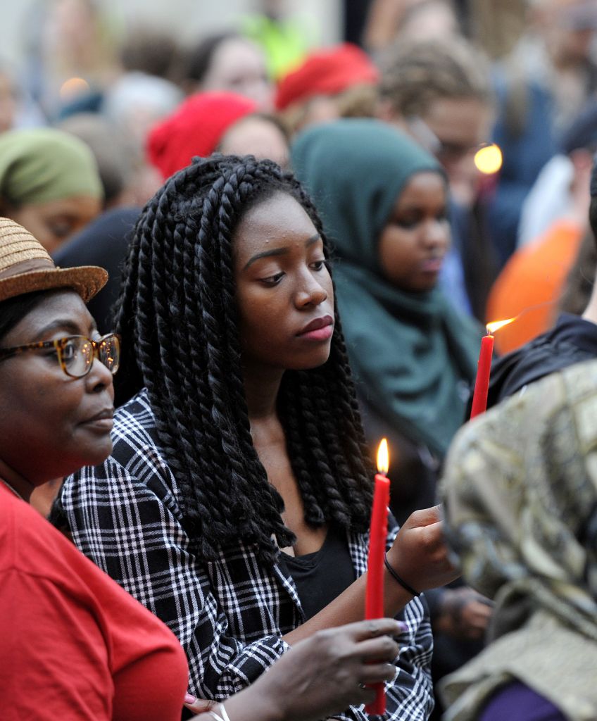 Madia Alluding and her granddaughter Danielette Johnson hold candles at city hall in Portland, Maine, during a vigil to remember two black men shot and killed by police in Louisiana and Minnesota, Friday, July 8, 2016. (Photo by Shawn Patrick Ouellette/Portland Press Herald via Getty Images)