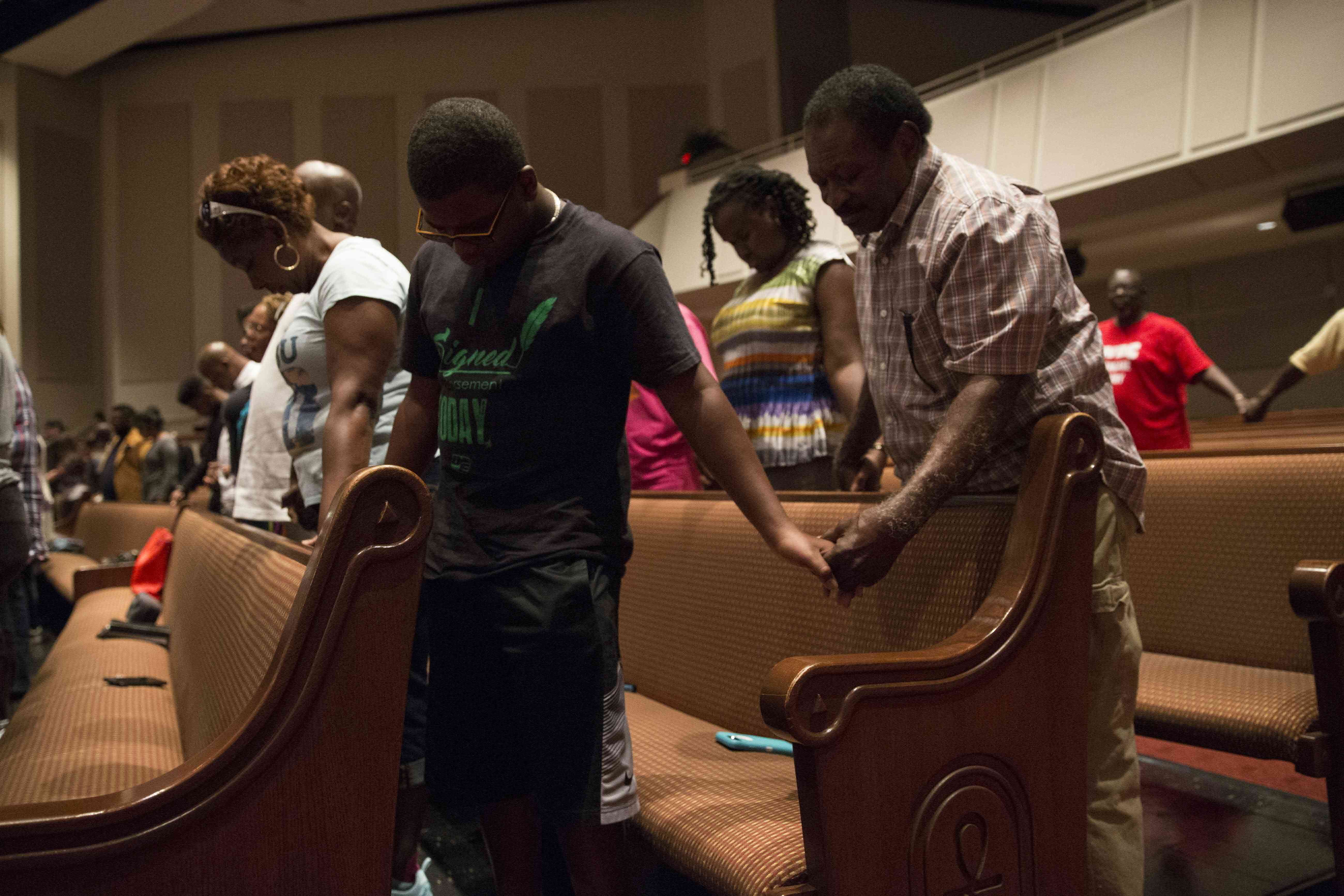 Parishioners of Frienship-West Baptist Church in Dallas pray together on July 10, 2016, during a "Community Conversation" event following the recent sniper attacks against white police officers. (Photo by Laura Buckman/AFP/Getty Images)