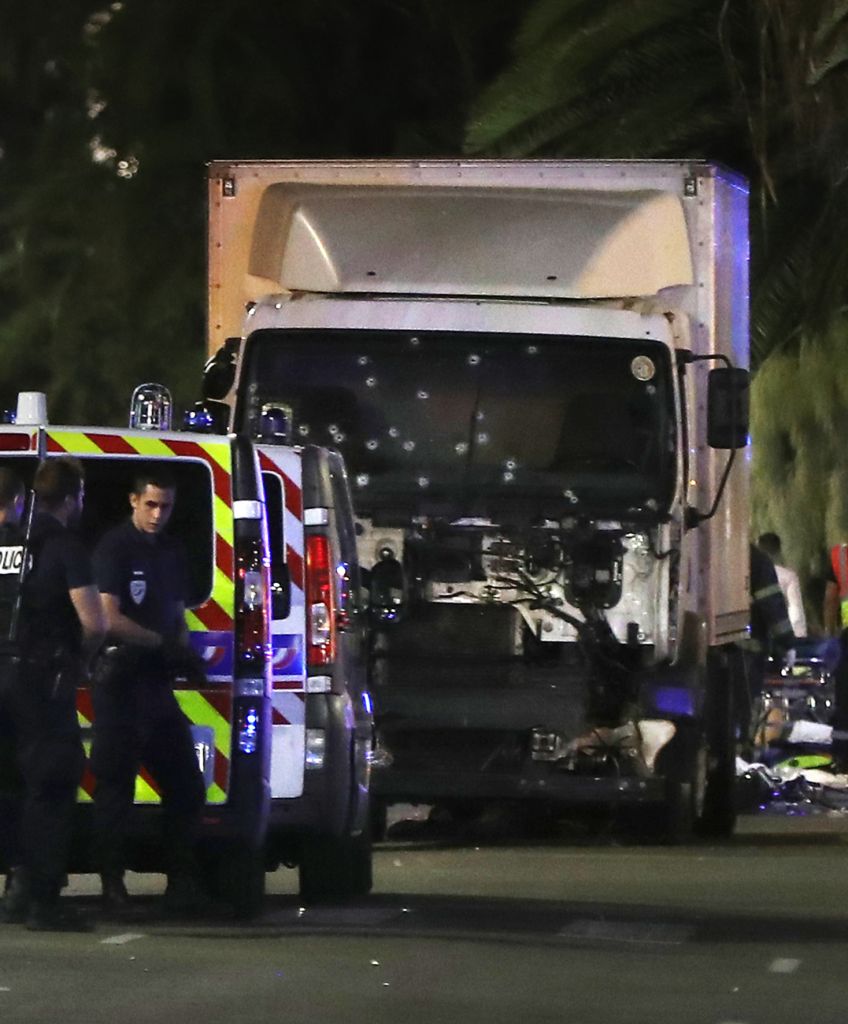 Police officers and rescue workers stand near a truck that plowed into a crowd leaving a fireworks display in the French Riviera town of Nice on July 14, 2016. (VALERY HACHE/AFP/Getty Images)