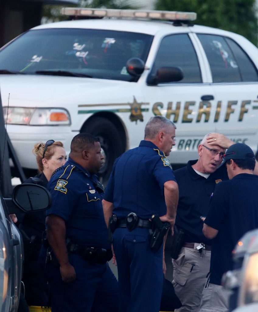 Police officers stand in front of an East Baton Rouge police car with bullet holes as it's towed away from the scene where three police officers were killed on July 17, 2016. The suspect, identified as Gavin Long of Kansas City, is dead after killing three police officers and injuring three more. (Photo by Sean Gardner/Getty Images)