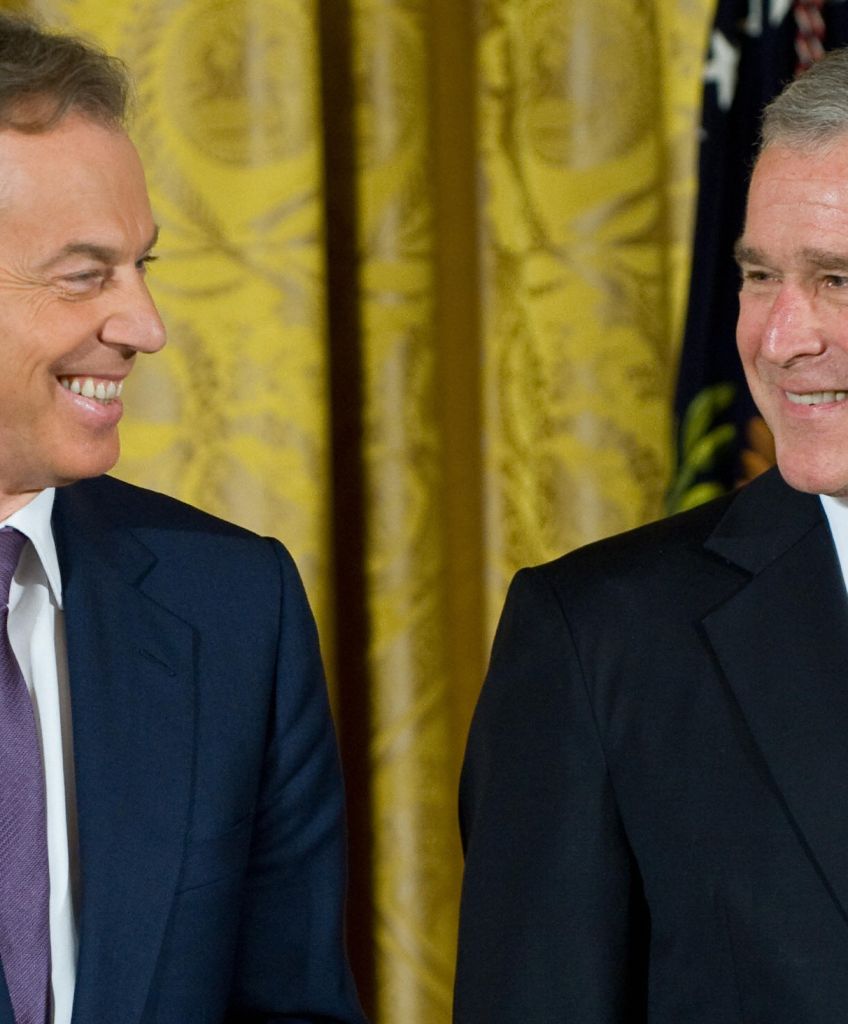 George W. Bush smiles alongside former British Prime Minister Tony Blair prior to presenting him with the Presidential Medal of Freedom in the East Room of the White House in Washington, DC, January 13, 2009. (SAUL LOEB/AFP/Getty Images)