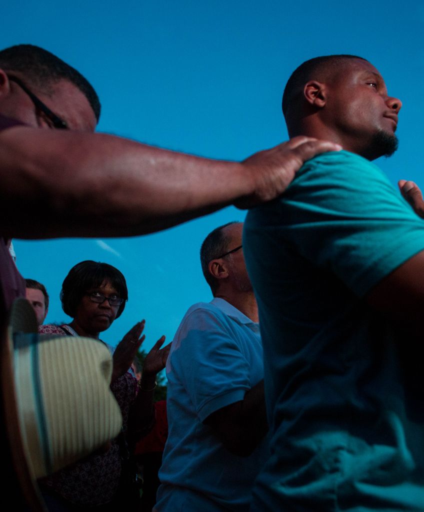 People gather for a prayer vigil near the BP gas station that was burned after an officer-involved killing August 14, 2016 in Milwaukee, Wisconsin. Angry crowds took to the streets for a second night to protest; people threw rocks and there was gunfire in the crowd. Hundreds of people confronted police after an officer shot and killed a fleeing armed man earlier in the day. (Photo by Darren Hauck/Getty Images)