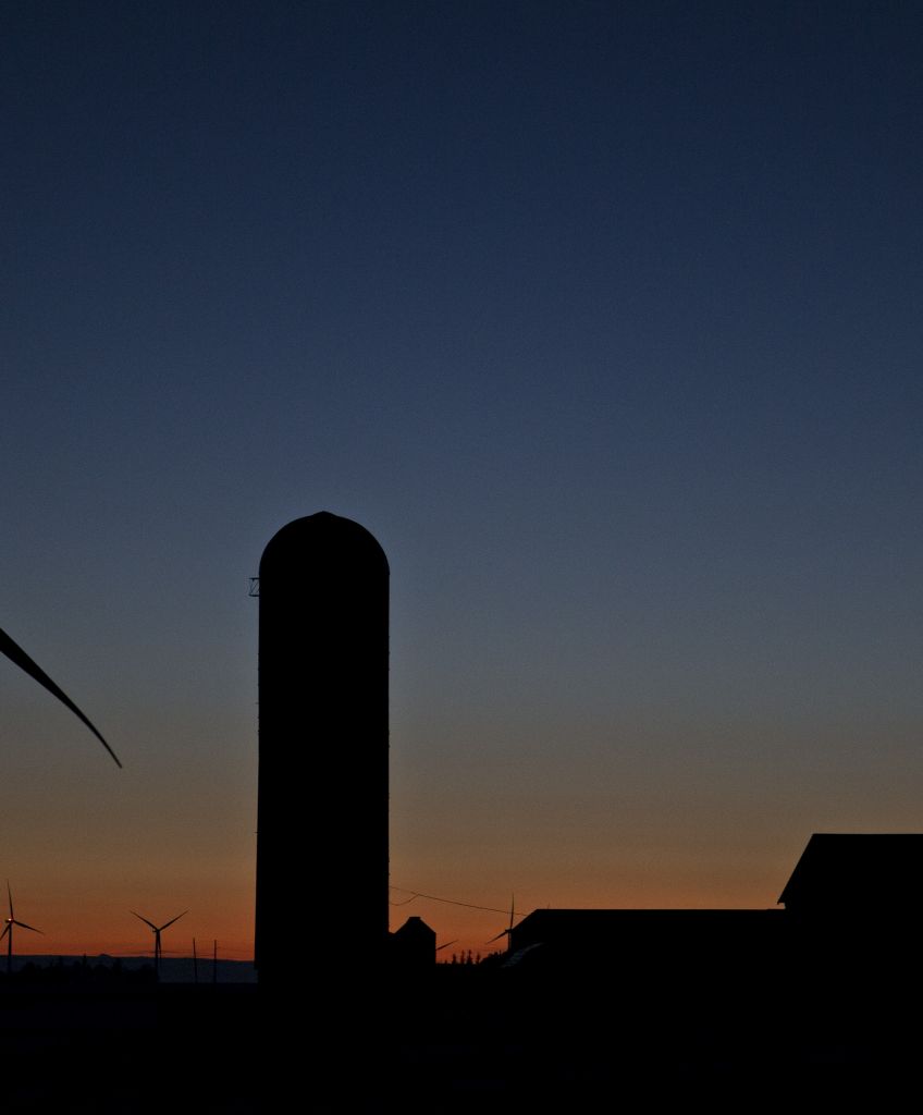 A windmill stands next to a grain silo near Wellsburg, Iowa. While urban and suburban incomes are growing, according to a new Census report, rural incomes are not. (Photographer: Andrew Harrer/Bloomberg via Getty Images)