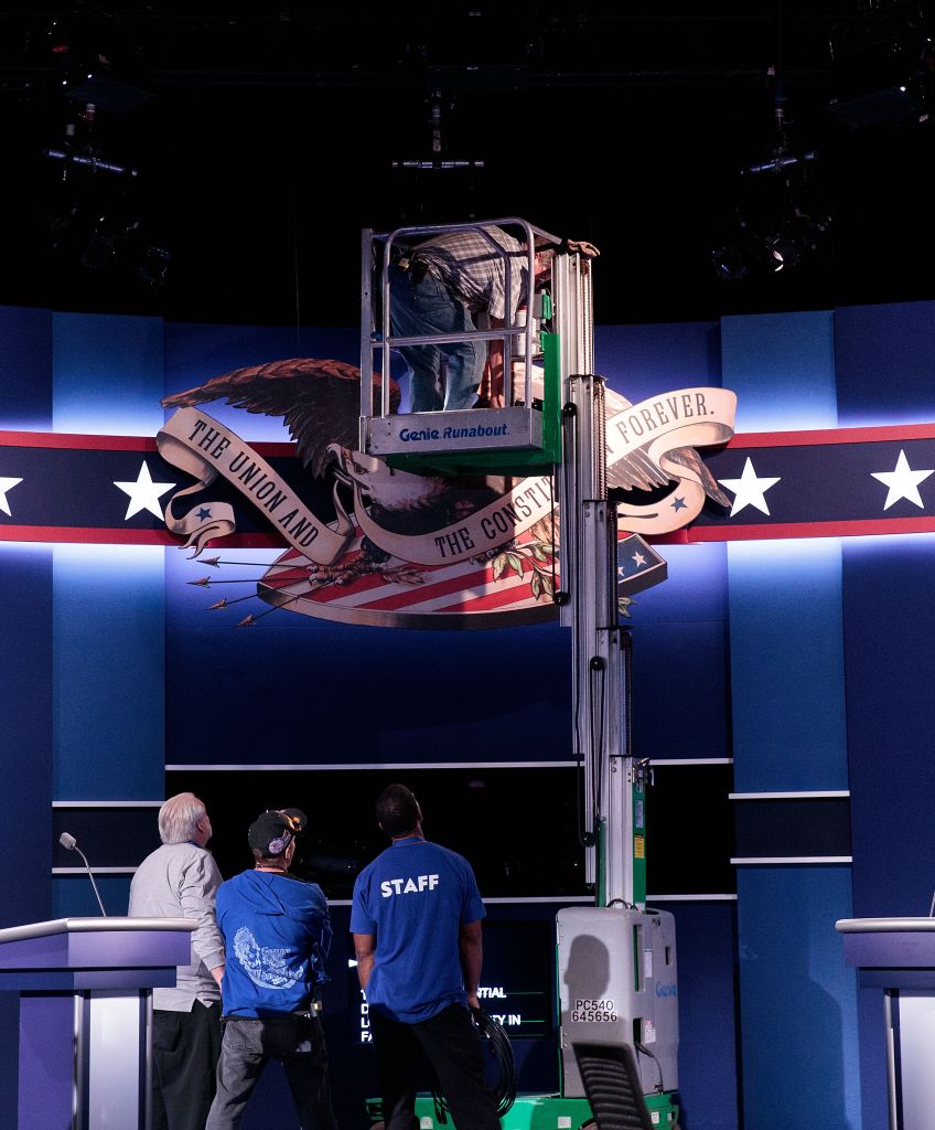 Workers make adjustments to the set for this year's first US presidential debate at Hofstra University in Hempstead, New York. (Photo by Drew Angerer/Getty Images)