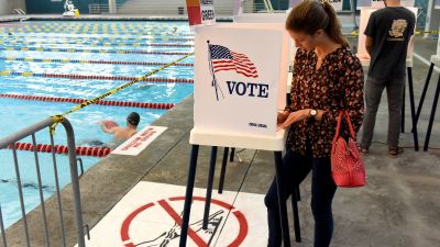 Woman at voting booth by swimming pool