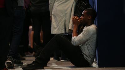 An attendee reacts while sitting on the floor during an election night party for 2016 Democratic Presidential Candidate Hillary Clinton at the Javits Center in New York, on Tuesday, Nov. 8, 2016. (Daniel Acker/Bloomberg via Getty Images)