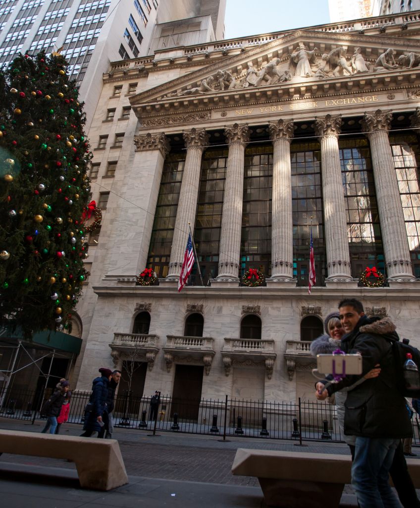 People take a selfie photograph in front of the New York Stock Exchange (NYSE) in New York on Monday, Nov. 28, 2016. (Photographer: Michael Nagle/Bloomberg via Getty Images)