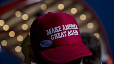An attendee wearing a hat reading "Make America Great Again" waits for the arrival of Donald Trump during a campaign event in Cedar Rapids, Iowa, on Friday, Oct. 28, 2016. (Photographer: Daniel Acker/Bloomberg via Getty Images)
