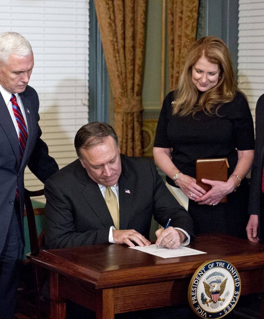 Representative Mike Pompeo, a Republican from Kansas, second left, signs the affidavit of appointment after being sworn-in as director of the Central Intelligence Agency (CIA), as US Vice President Mike Pence, left, Pompeo's wife Susan Pompeo, second right, and their son Nick Pompeo look on in Washington, DC, Monday, Jan. 23, 2017. (Photographer: Ron Sachs/Pool via Bloomberg)