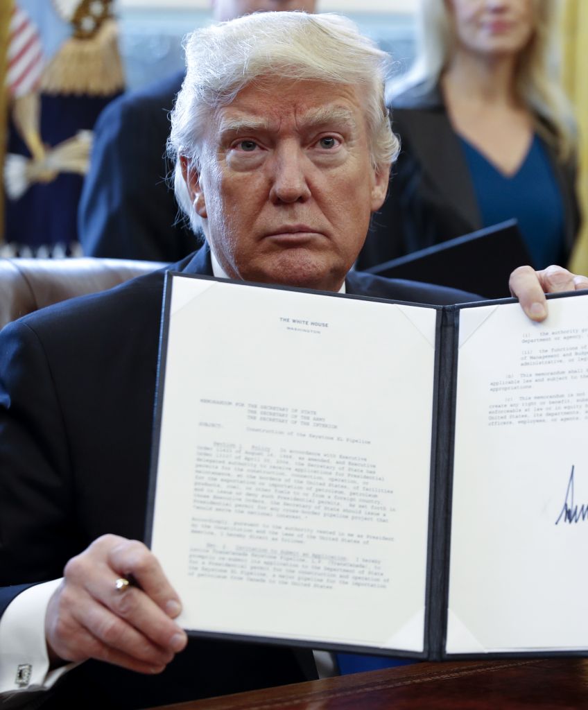 In the Oval Office, President Donald Trump displays one of five executive orders he signed related to the oil pipeline industry, Tuesday, Jan. 24, 2017. Trump took steps to advance construction of the Keystone XL and Dakota Access oil pipelines while foreshadowing a "renegotiation" of terms and insisting that developers use U.S. steel. Photographer: Shawn Thew/Pool via Bloomberg