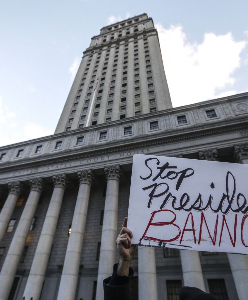 A demonstrator displays a sign that reads "Stop President Bannon" outside Federal Plaza in New York on Sunday, Jan. 29, 2017. (Photographer: Jeenah Moon/Bloomberg via Getty Images)