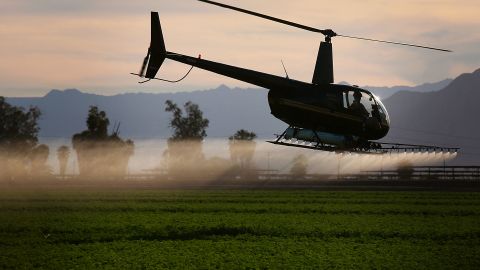 A helicopter sprays insecticide on a field outside of El Centro, California in the Imperial Valley on Feb. 11, 2015. The Imperial Valley has some of the poorest air quality in California due to border traffic, farming and other industries. (Photo by Sandy Huffaker/Corbis via Getty Images)