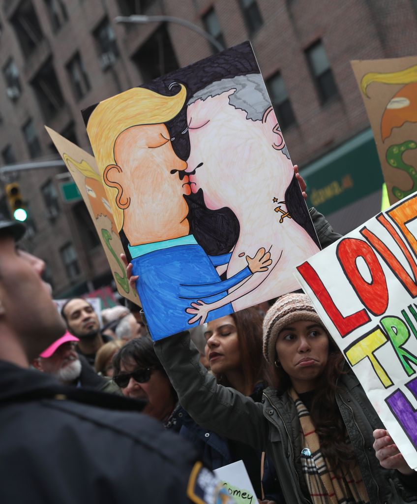 People hold up a drawing of Donald Trump and Vladimir Putin kissing during the Women's March on Jan. 21, 2017 in New York City. (Photo by John Moore/Getty Images)