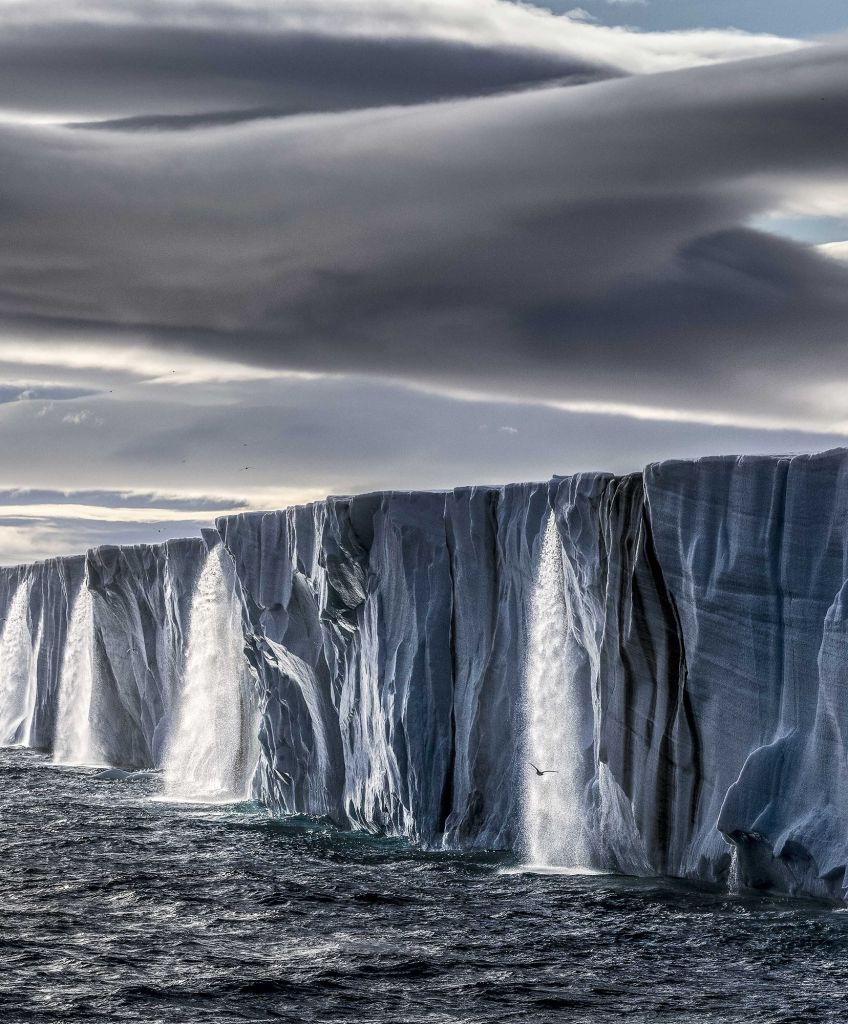 Meltwater gushes from an ice cap on the island of Nordaustlandet, in Norway's Svalbard archipelago. (Photo courtesy of Paul Nicklen)