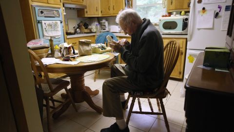 Joseph Horecky, 90 and with a vision impairment, makes a call from his kitchen after receiving a "Meals on Wheels" delivery from the Sullivan County Office for the Aging on Sept. 21, 2012 in Barryville, New York. The nutrition program is for residents age 60 and older and is funded by federal, state and county grants. (Photo by John Moore/Getty Images)