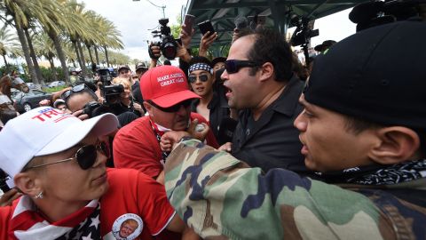 Anti-Trump protesters (right) clash with Donald Trump supporters (left) outside the Anaheim Convention Center during a rally for Republican presidential candidate Donald Trump on May 25, 2016 in Anaheim, California. Dozens of security personnel including police on horseback maintained control in Anaheim, although some skirmishes broke out between Trump opponents and his backers as protesters chanted expletives about the brash billionaire. At least two arrests were made. (Photo by Mark Ralston/AFP/Getty Images)