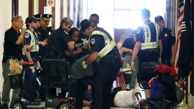 Police remove protesters from in front of the office of Senate Majority Leader Mitch McConnell (R-KY) inside the Russell Senate Office Building in Washington, DC on June 22, 2017. Members of a group with disabilities were protesting the proposed GOP health care plan. (Photo by Mark Wilson/Getty Images)