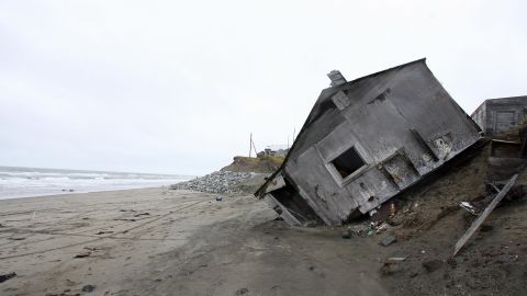A home destroyed by beach erosion lies on its side in the the Alaskan village of Shishmaref. (Photo by Gabriel Bouys/AFP/Getty Images)