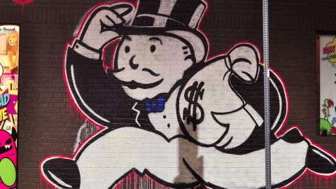 We’re missing billions in taxes each year. That’s partly why our roads and transit systems are falling apart. (Mural by graffiti artist Alec Monopoly / Photo by aisletwentytwo | Flickr CC 2.0)