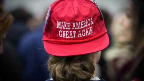 A supporter wearing a hat with the Trump campaign slogan, "Make America Great Again," waits for the start of a campaign rally for then-Republican presidential candidate Donald Trump in Holderness, New Hampshire, on Feb. 7, 2016. (Photo by Keith Bedford/The Boston Globe via Getty Images)