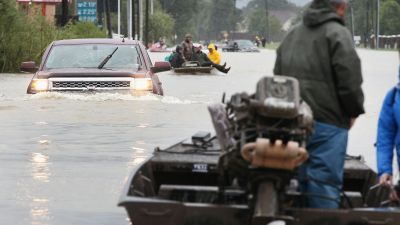 Rescue workers and volunteers help residents make their way out of a flooded neighborhood after it was inundated with rain water following Hurricane Harvey on Aug. 29, 2017 in Houston. This is what Texans were bracing for when Trump announced the military transgender ban and the Arpaio pardon four days earlier. (Photo by Scott Olson/Getty Images)