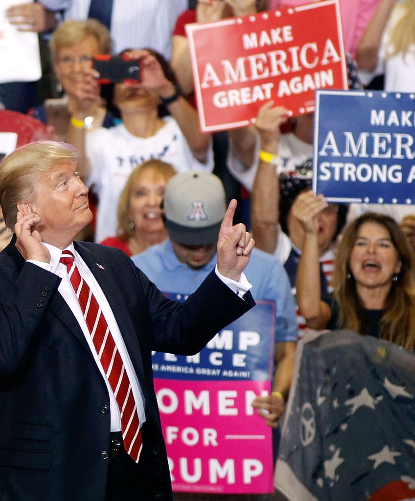 President Donald Trump gestures to the crowd of supporters at the Phoenix Convention Center as he takes the stage during a rally on Aug. 22, 2017. (Photo by Ralph Freso/Getty Images)