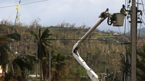 A worker repairs power lines in San Isidro, Puerto Rico, on Oct. 5, 2017, about two weeks after Hurricane Maria swept through the island. (Photo by Mario Tama/Getty Images)