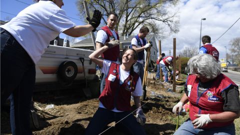 Wendy Buchner (left) high-fives Emily Miller (center) after Buchner, Miller and Cindy Scheneman (right) dug a fence post hole for a new fence at a house on April 13, 2016. Rebuilding Together Metro Denver and Lowes provided critical repairs and upgrades to four homes and the ACS Community Lift building. ACS is a nonprofit that provides the west Denver community with a food bank, limited free medical care and work force opportunities. (Photo by Andy Cross/The Denver Post via Getty Images)