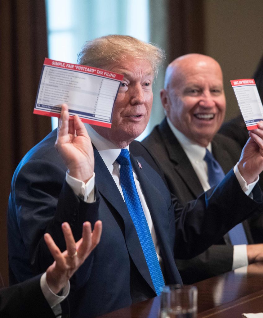 President Donald Trump shows samples of the proposed new tax form as he meets with House Republican leaders and Republican members of the House Ways and Means Committee at the White House in Washington, DC, on Nov. 2, 2017. (Photo by Nicholas Kamm/AFP/Getty Images)