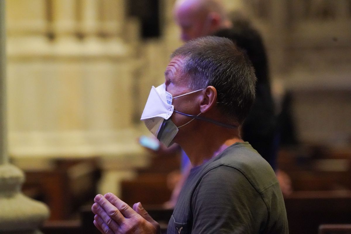 A man wearing a face mask prays inside St. Patrick's Cathedral as it re-opens for Mass at 25% capacity amid the coronavirus pandemic on June 28, 2020 in New York. (Photo by Bryan R. Smith / AFP) (Photo by BRYAN R. SMITH/AFP via Getty Images)